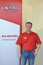 Annahmemeister Herbert Metzten vor Kia Motors Logo Wand