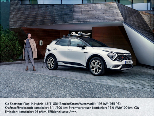 Kia Home- charging geparkter Kia vorm Haus mit Frau im Mantel