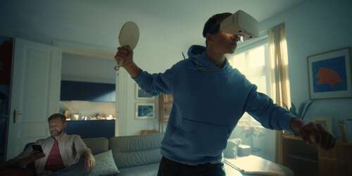 Kia Vater und Sohn zu Hause im Wohnzimmer mit digitaler Brille zum Tischtennis spielen